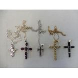 A black diamond inset cross on chain, a silver and mother of pearl cross, a purple garnet cross