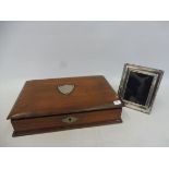 A silver photograph frame and an Edwardian mahogany writing box with white metal shield-shaped