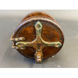 A wood and brass 3 1/2" star back centre pin fishing reel.