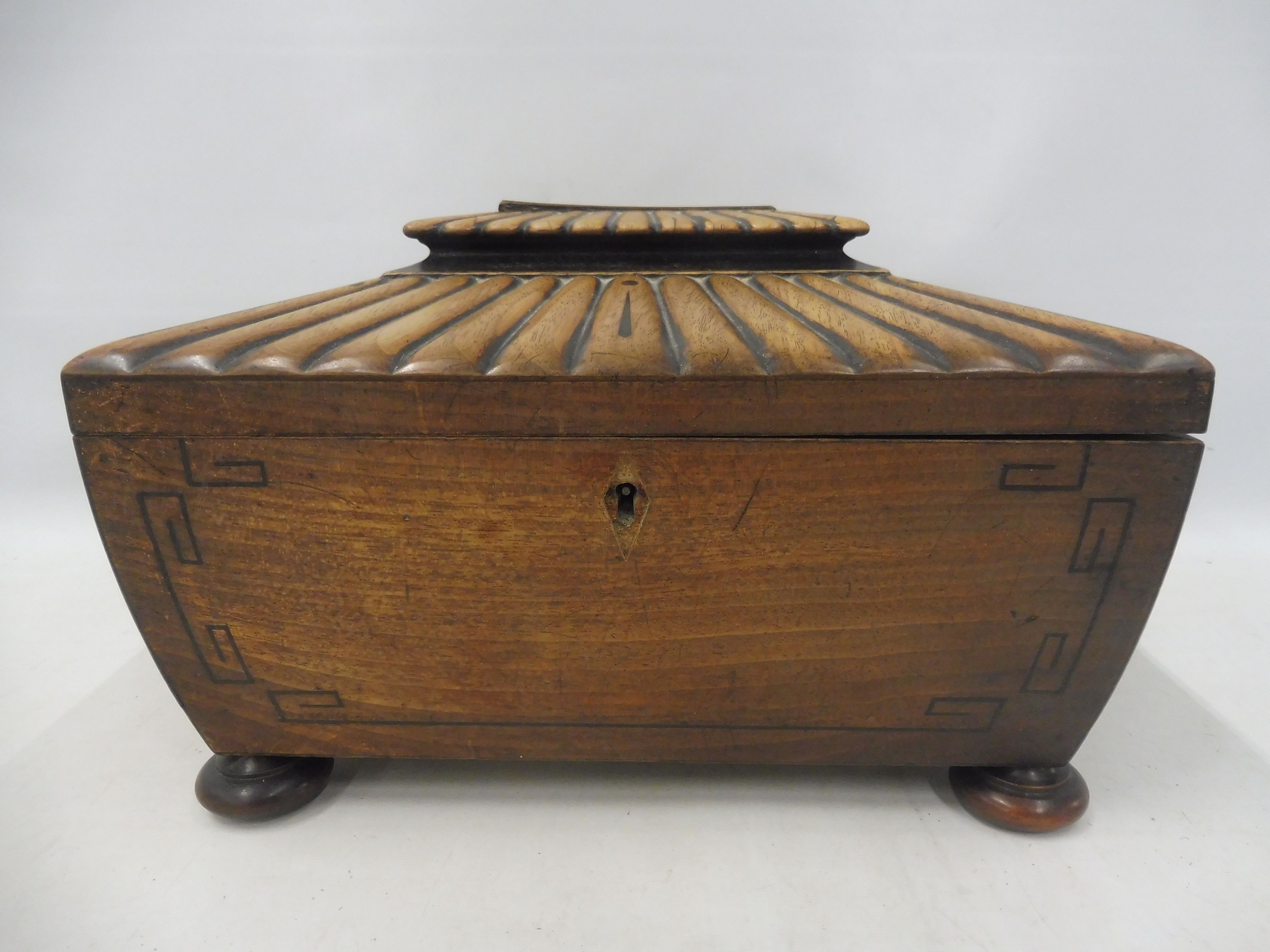 A Regency mahogany ebony strung and burr yew inlaid sarcophagus-shaped sewing box with brass ring