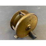 A small Millward 2 1/2" centre pin fishing reel with arm and sword mark.
