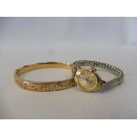 A 9ct gold bangle plus a 9ct gold cased ladies wristwatch bangle, approx. 11.3g.