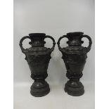 A pair of black moulded plaster classical style urns.