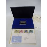 A boxed Danbury Mint Silver Jubilee Post Office commemorative stamp edition silver ingot and first