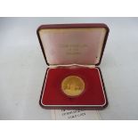 A cased 1974 Commonwealth of the Bahamas 100 dollar gold coin, with information card.