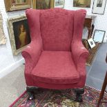 A 19thC wing back Armchair, in red upholstery, raised on cabriole legs with ball and claw feet82cm