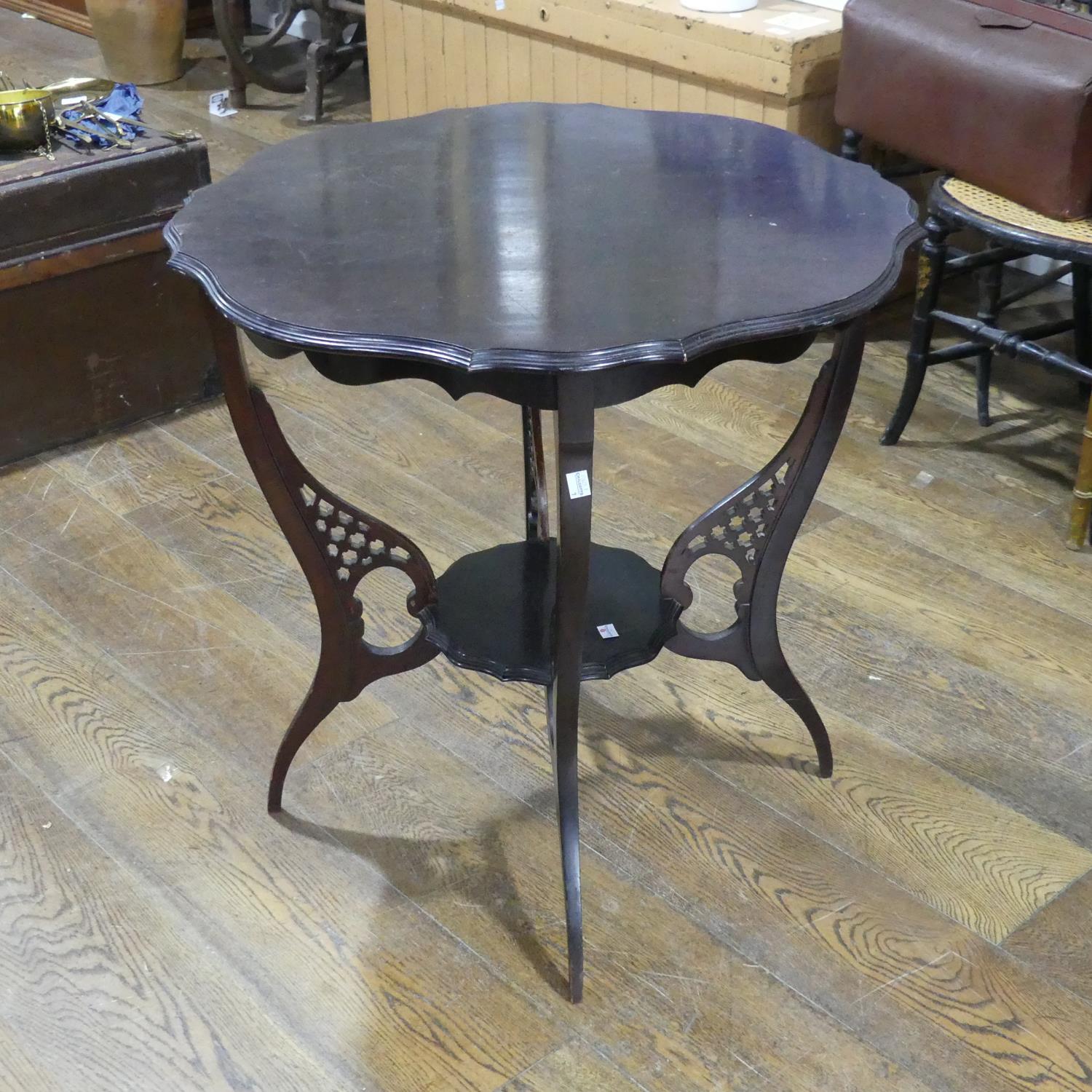 An Edwardian mahogany two-tier occasional Table, the top with gadrooned edge, raised upon pierced