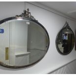 A pair of early 20thC oval Wall Mirrors, with silver-plated frames enclosing the bevel edged