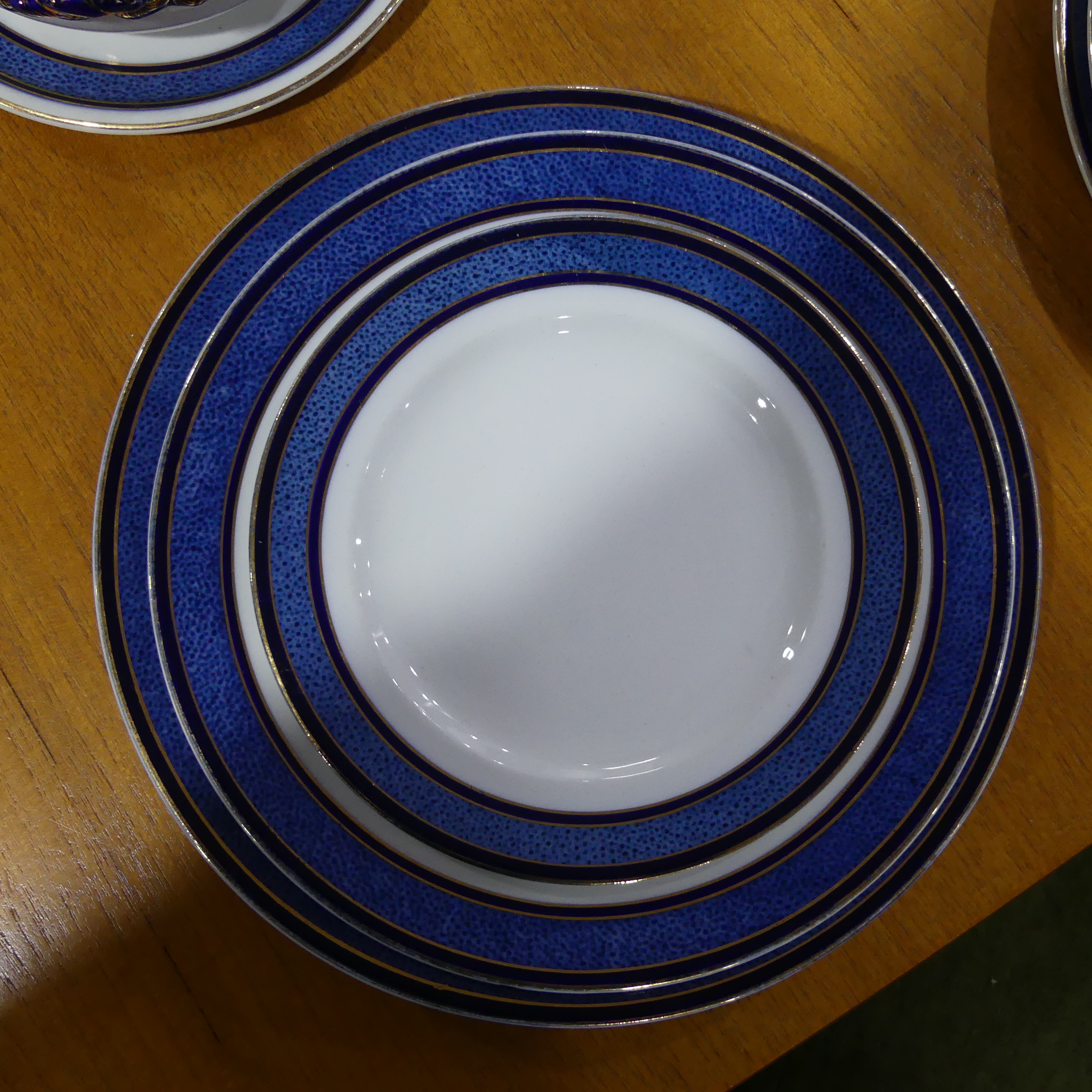 An early 20thC Staffordshire Dinner Service, decorated in blue banding with gilding, comprising five - Image 2 of 8