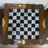 An Oriental Chess Set, the carved wood enclosing black and white tiles, the white depicting