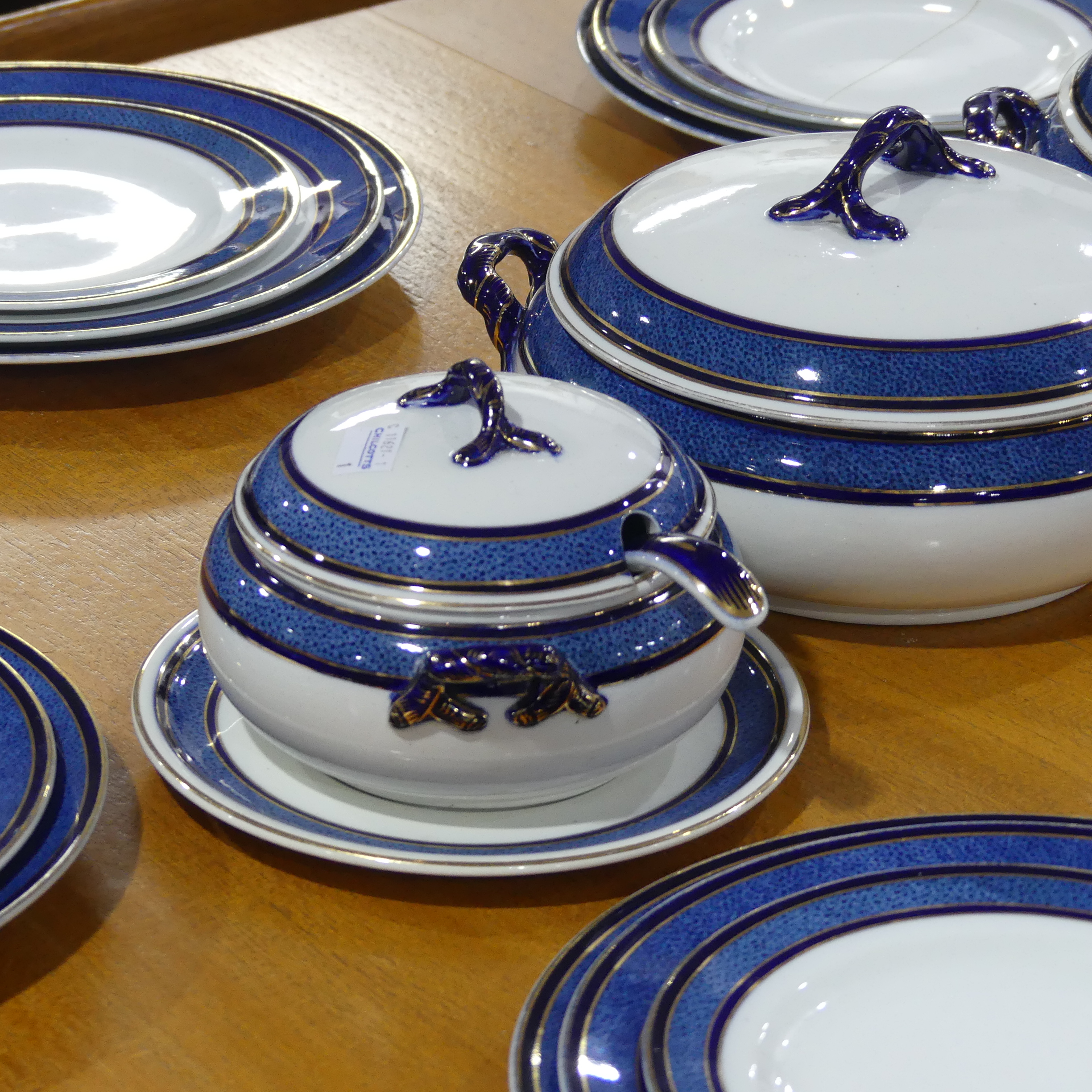 An early 20thC Staffordshire Dinner Service, decorated in blue banding with gilding, comprising five - Image 3 of 8