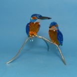 A Swarovski Crystal Kingfisher Duo, the two cut glass birds, perched upon metal branch, impressed
