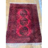 Tribal Rugs: a red ground Afghan hand knotted rug, the whole woven with tekke and guls within a wide