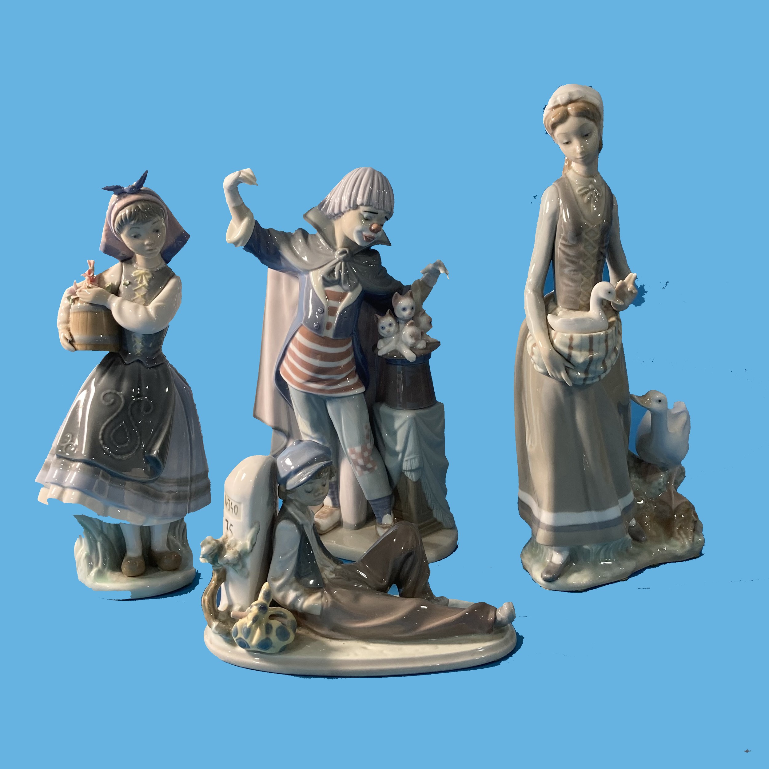 A small quantity of Lladro, to include a Magician, a Lady feeding Ducks, a young Fisherman and one