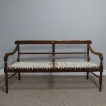 An early 20th century mahogany framed Settle, lacks upholstered seat, raised on turned legs, 58in (