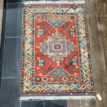 Tribal Rugs: a Turkish hand knotted wool rug, the orange ground woven with bold geometric patterns