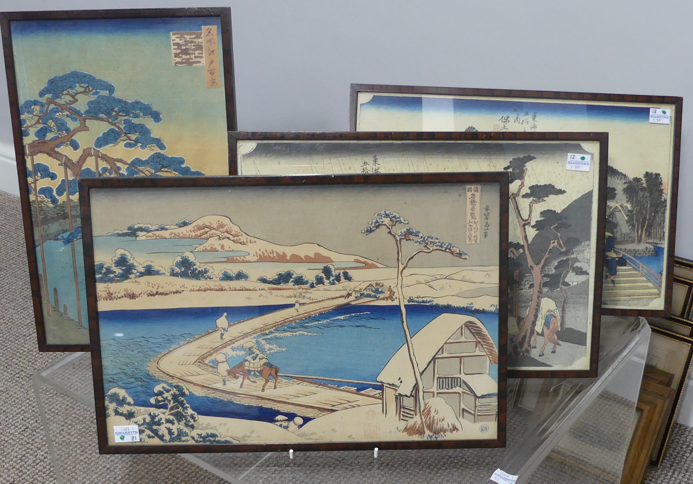 A pair of early 20th century Japanese woodblock prints, depicting figures in landscapes, 23cm x