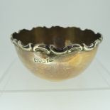 A small Edwardian circular silver Bowl, hallmarked Chester, 1906, with moulded scrolling rim, 10cm