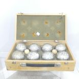 A cased set of eight 'Obut' metal Boules, and two jacks in pine case.