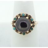 A garnet Dress Ring, the cabochon garnet claw set above a gold border set six small turquoise, all