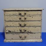 A rustic table-top Chest of Drawers, comprising five graduated drawers, in distressed cream paint, W