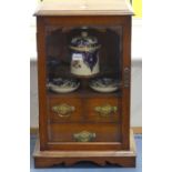 An Edwardian oak smokers Cabinet, with bevelled glass door enclosing fitted interior housing an