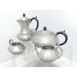 An Arts & Crafts style pewter four piece tea Service, teapot, hot water Jug, creamer and sugar bowl,