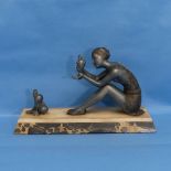 A French Art Deco spelter group a young woman with doves, on marbled rectangular base, W 38.5cm x