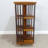 An Edwardian style mahogany revolving Bookcase, the top with stylised floral motif and herringbone