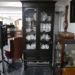 An early 20th century oak Bookcase, with leaded glazed doors, raised on turned block legs, lead