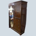 An Edwardian inlaid mahogany Compactum Wardrobe, the door with full length oval mirror, W 148cm x