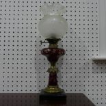 An antique brass and engraved cranberry glass Oil Lamp, 63cm high.