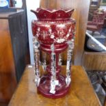 A ruby glass Lustre, with a castellated rim and clear glass pendants, 38cm high