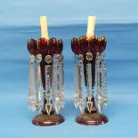 A pair of late Victorian ruby glass Lustres, each with a castellated rim and clear glass pendants,