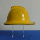 A yellow cork Fire Helmet, circa 1993, with leather lining and Northamptonshire transfer badge,