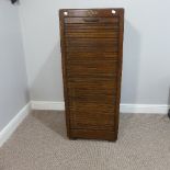 An early 20thC oak pedestal Filing Cabinet, with locking full tambour front exposing the nine tray