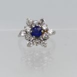 A sapphire and diamond cluster Ring, the central circular facetted sapphire surrounded by eleven