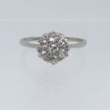 A diamond cluster Ring, the central old cut stone surrounded by six further old cut stones, all