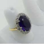 An amethyst and diamond Dress Ring, the oval facetted amethyst surrounded by twenty small diamond