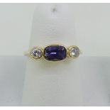 A colour change sapphire and diamond three stone Ring, the central oval sapphire, approx 1ct, with a