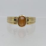 A 9ct yellow gold Signet Ring, collet set with an oval Tiger's Eye, Size T, 4.5g.