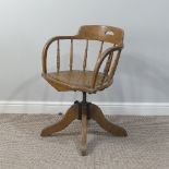 A late 19thC/ early 20thC oak bow-arm swivel Desk Chair, with cast iron screw adjustment