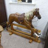 A mid 20thC child's Rocking Horse, with leather ears, saddle, harnesses and mane, raised on