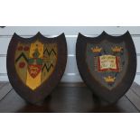Huyshe Family / Oxford University, a pair of metal shield-shaped coats of arms, on corresponding oak