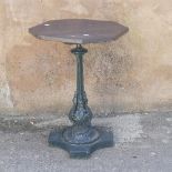Garden Statuary; An antique cast iron Garden Table, the wooden hexagonal top upon green-painted leaf