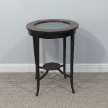 An early 20thC inlaid mahogany circular Bijouterie Table, with circular glazed lift up top with