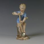 A 19thC Meissen porcelain figure of a Young Gardener, the boy modelled digging with a spade, on oval