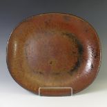 A Michael Leach studio pottery Dish, with iron red mottled ground, with impressed marks for