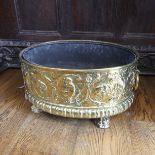 An antique brass Wine Cooler, with embossed decoration of cherubs and leaves, metal lining, brass