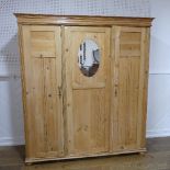 A Victorian pine Wardrobe, with bead moulded cornice above three panelled doors, with central